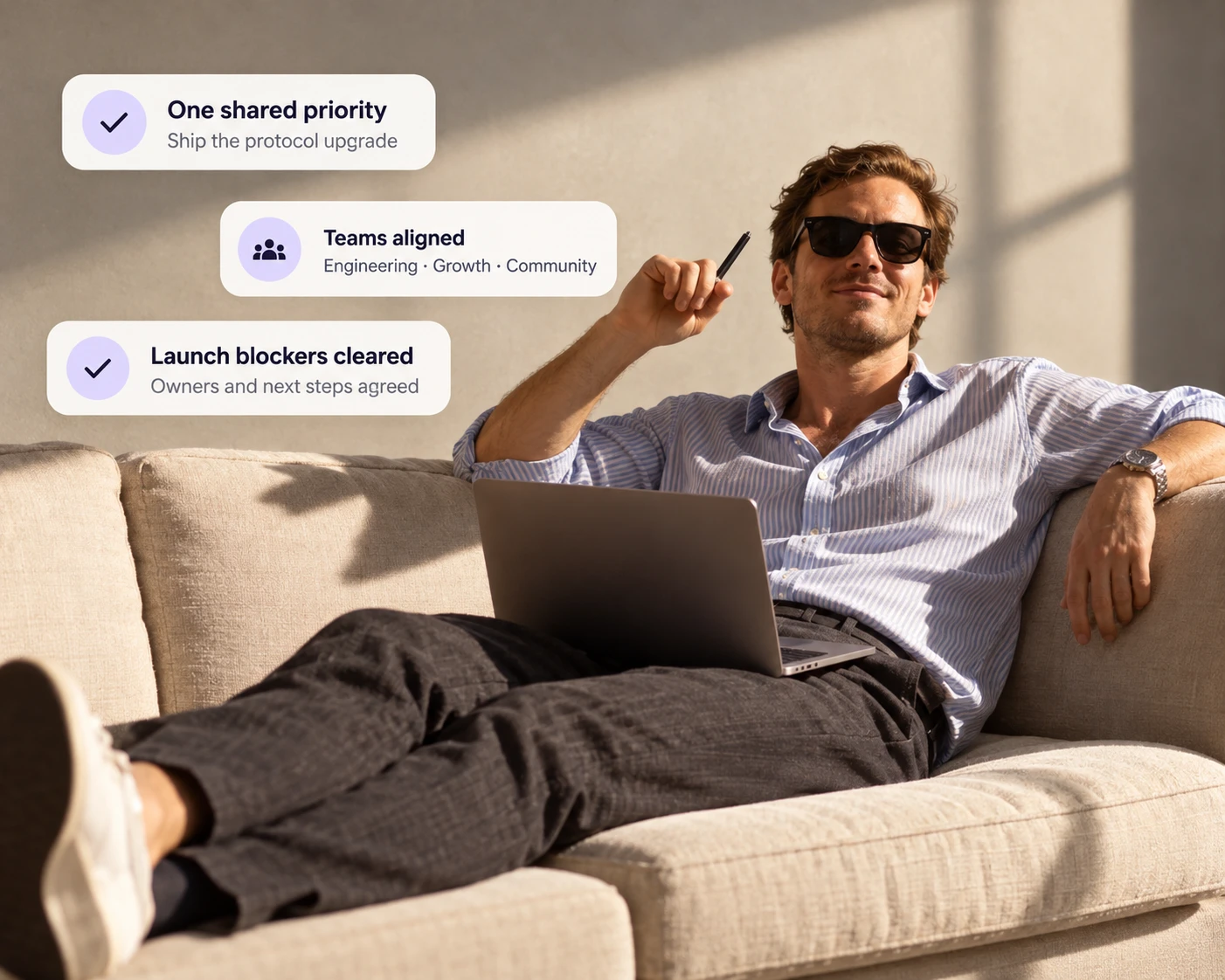 A founder relaxing on a sofa with a laptop, with Decided cards showing one shared priority, teams aligned and launch blockers cleared
